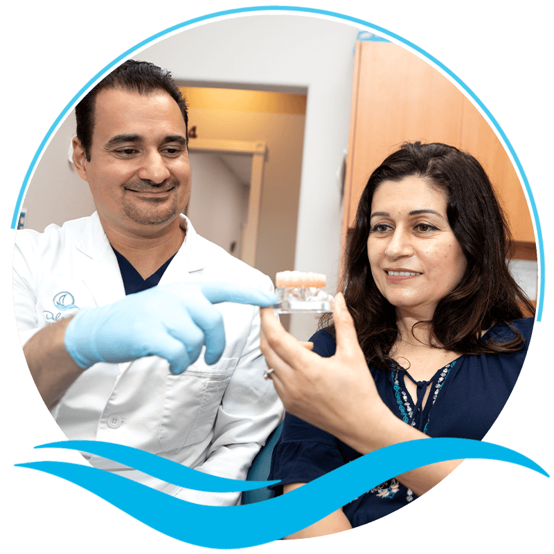 Doctor pointing at a model of Full arch implants